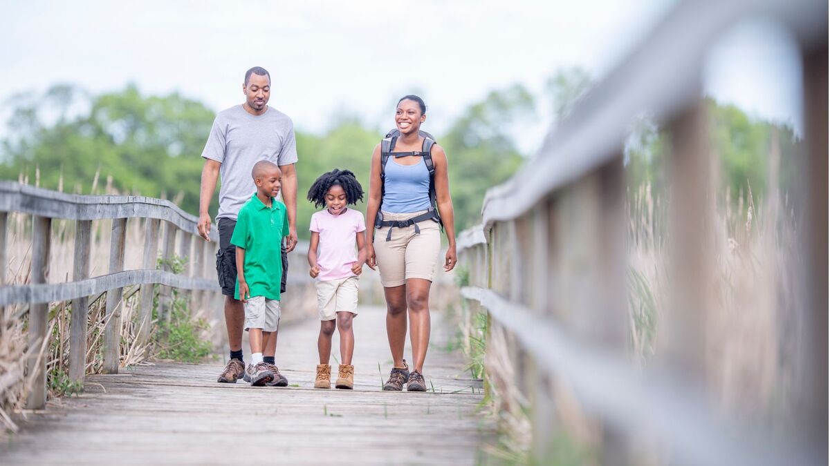 Family taking a walk along a wooden bridge