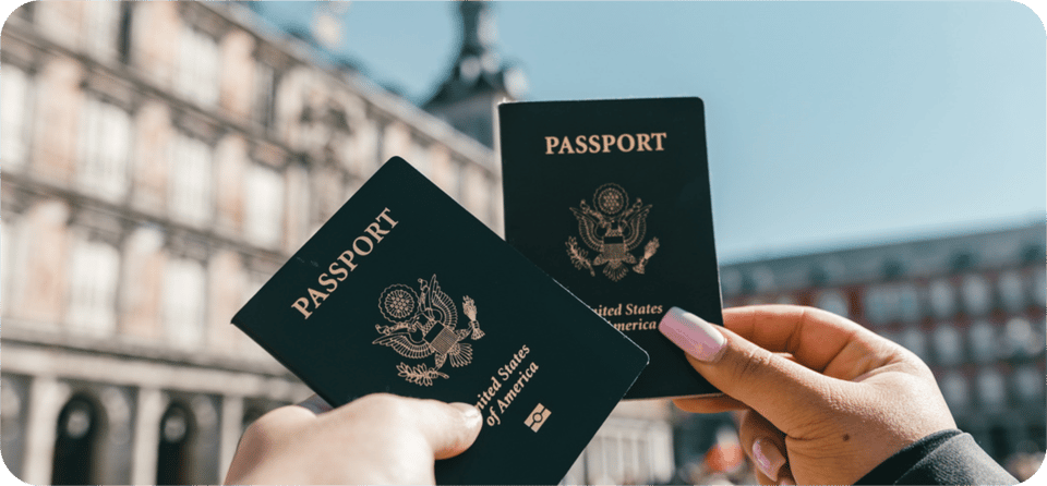 2 travelers holding out their passports