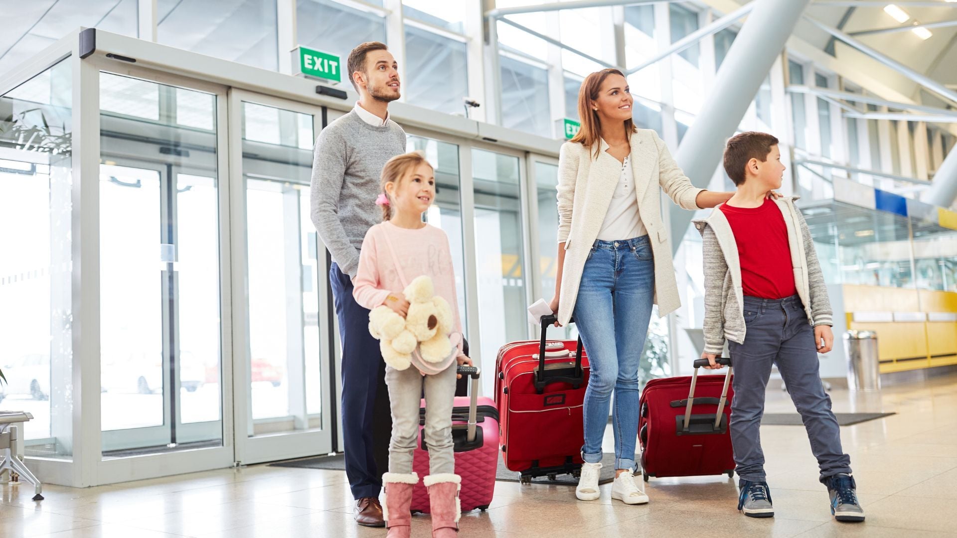 A family in the airport waiting to get on the plane