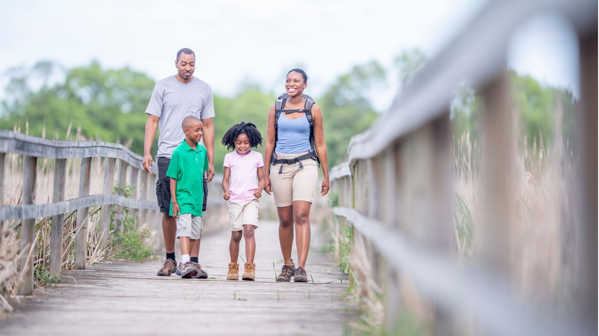 Family taking a walk along a wooden bridge