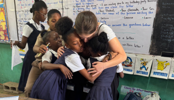 A group hug between students and their teacher